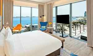 Hotellrom med utsikt over havet og palmetrær. (AI-generert tekst)