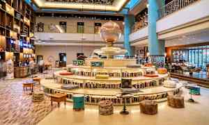 Interiør av et hotell med bokhylle rundt en rund sitteplass og dekorativ atmosfære. (AI-generert tekst)