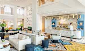 En elegant hotellobby med moderne møbler og en marmordisk. (AI-generert tekst)