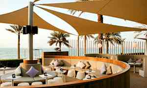 En sittegruppe med skygge og utsikt over havet. (AI-generert tekst)