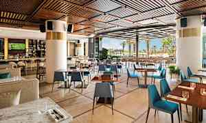 En moderne restaurant med tredetaljer og utsikt mot utendørsområdet. (AI-generert tekst)