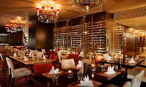 En elegant restaurant med oppdekkede bord, polstrede stoler og lysekroner i taket. (AI-generert tekst)