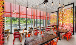 En kafé med fargerike møbler og vegger med dekorative detaljer. (AI-generert tekst)