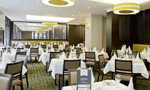 En elegant restaurant med hvite duker og borddekking. (AI-generert tekst)