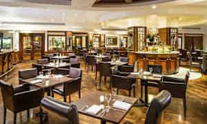 En elegant restaurant med bord og stoler, klargjort for måltider. (AI-generert tekst)