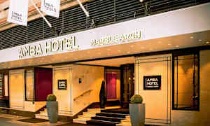 Inngangen til Amba Hotel Marble Arch med skilt og flagg. (AI-generert tekst)