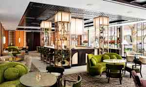 Bilde av en moderne hotellbar med elegante møbler og grønne dekorasjoner. (AI-generert tekst)