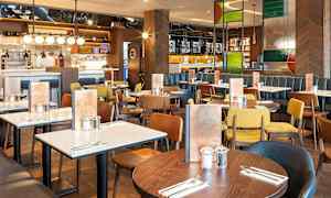 Restaurant med flere spisebord og stoler i forskjellige farger. (AI-generert tekst)