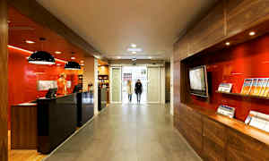 Resepsjon med moderne innredning og informasjonsbrosjyrer, plassert nær en glassinngang. (AI-generert tekst)