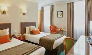 Hotellrom med to enkeltsenger og bord. (AI-generert tekst)