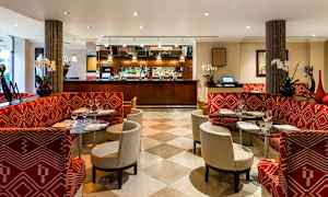 Restaurant med røde benker og glassbord. (AI-generert tekst)