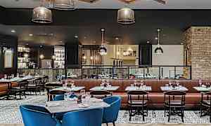 En stilig restaurant med bord, stoler og belysning. (AI-generert tekst)