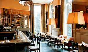 En elegant bistro med bar og bord med duker, arrangert ved store vinduer. (AI-generert tekst)