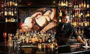 En bar fylt med flasker med brennevin og tilbehør, med et maleri av en figur i bakgrunnen. (AI-generert tekst)