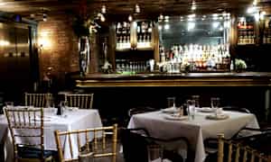 En restaurant med dekkede bord og en bardisk i bakgrunnen. (AI-generert tekst)