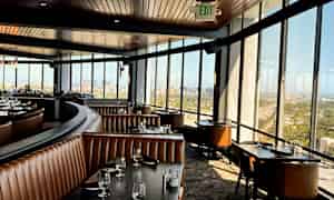 Interiør av en romslig restaurant med panoramautsikt gjennom store vinduer. (AI-generert tekst)