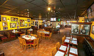 En restaurant med bord og stoler, fargerike vegger og dekor. (AI-generert tekst)