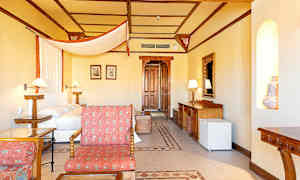 Et hotellrom med seng, tredetaljer og sittegruppe. (AI-generert tekst)