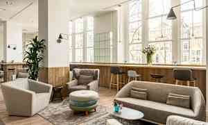 Moderne lounge med sofaer og lenestoler, store vinduer. (AI-generert tekst)