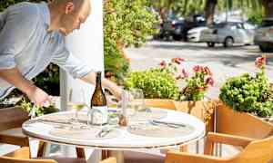 Et oppsatt bord utendørs med spiseplassen og dekorasjoner. (AI-generert tekst)