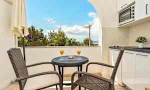 Balkong med bord, stoler og utsikt. (AI-generert tekst)