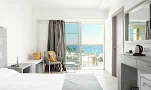 Lyst hotellrom med moderne innredning og havutsikt. (AI-generert tekst)