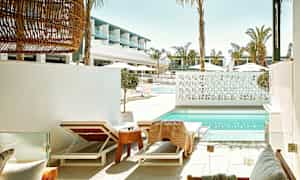 Solstoler ved et basseng med moderne arkitektur i bakgrunnen. (AI-generert tekst)