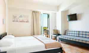 Et hotellrom med en seng, en sofa, en TV og en balkong. (AI-generert tekst)