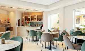 En moderne lounge med bord og stoler samt en velutstyrt bar. (AI-generert tekst)