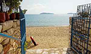 En strand med sand og en blå metallgrind. (AI-generert tekst)