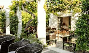 En frodig uteservering med hagemøbler og solrikt vær. (AI-generert tekst)