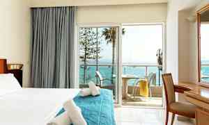 Hotellrom med balkong og utsikt over havet. (AI-generert tekst)