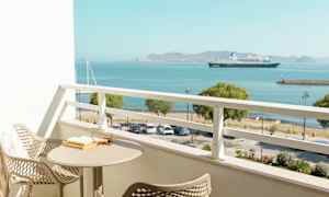 Balkong med utsikt over havet og et skip. (AI-generert tekst)