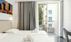 Hotellrom med to enkeltsenger, balkong med utsikt. (AI-generert tekst)