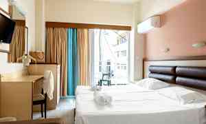 Hotellrom med dobbeltseng og skrivebord, samt balkong med utsikt. (AI-generert tekst)