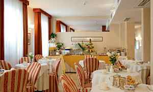 Et spiserom med dekkede bord og en buffé med frukt og juice. (AI-generert tekst)