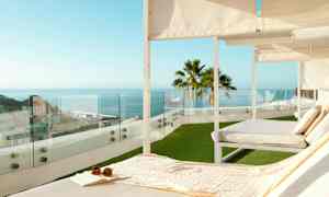 Solstoler på en terrasse med utsikt over havet og byen. (AI-generert tekst)