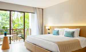 Et hotellrom med en dobbeltseng, lyse møbler og en balkong med utsikt mot hagen. (AI-generert tekst)