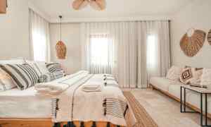 Et lyst og stilfullt soverom med en dobbeltseng, dekorative puter og tekstiler. (AI-generert tekst)