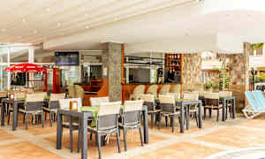 Restaurant med uteservering og bar, omgitt av stoler og bord. (AI-generert tekst)