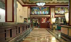 Inngangshall med marmorgulv, resepsjonsdisk og dekorativt innertak. (AI-generert tekst)