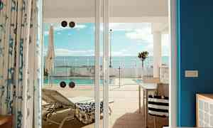 Bilde av en solseng og et basseng, sett fra en terrasse gjennom glassdører. (AI-generert tekst)