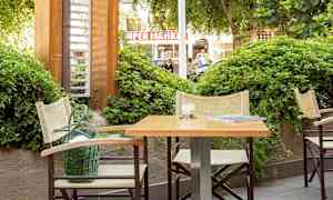 Utendørsmiljø med bord og stoler ved siden av grønnsaker. (AI-generert tekst)