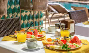 En oppdekket hotellfrokost ved bassengområdet. (AI-generert tekst)