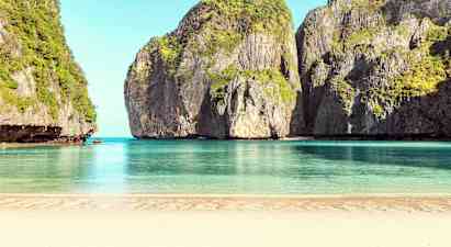 En sandstrand med rolig blått vann, omgitt av høye klipper dekket av vegetasjon. (AI-generert tekst)