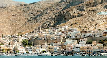 En kystby med små hus på en fjellskråning. (AI-generert tekst)