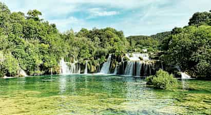 Et naturskjønt fossefall omgitt av frodig vegetasjon. (AI-generert tekst)