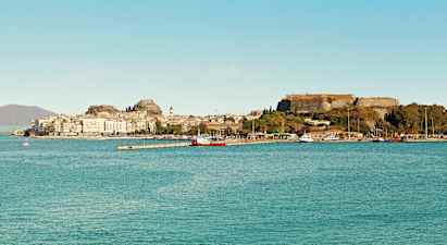 En by ved havet med historiske bygninger og en festning på en høyde. (AI-generert tekst)