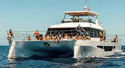 En hvit motorbåt på havet med mennesker som nyter solen. (AI-generert tekst)