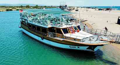 En båt ligger ved en brygge nær stranden. (AI-generert tekst)